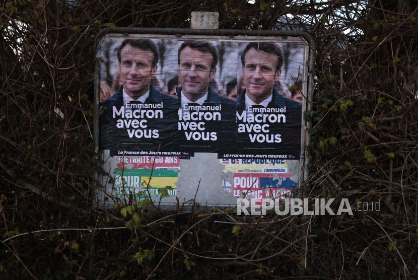 Poster pemilu untuk Presiden Prancis Emmanuel Macron dan kandidat tengah untuk pemilihan kembali, Selasa, 22 Maret 2022 difoto di Vigneux-de-Bretagne, Prancis barat. Putaran pertama pemilihan presiden Prancis berlangsung pada 10 April, dengan pemilihan presiden putaran kedua pada 24 April jika tidak ada kandidat yang langsung menang.