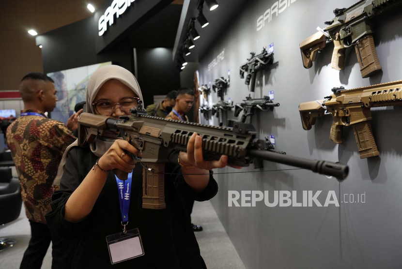 Seorang pengunjung memegang senapan serbu SAR 56 pada hari pembukaan Indo Defence Expo 2022 di JIExpo, Kemayoran,Jakarta Pusat, Rabu (2/11/2022).