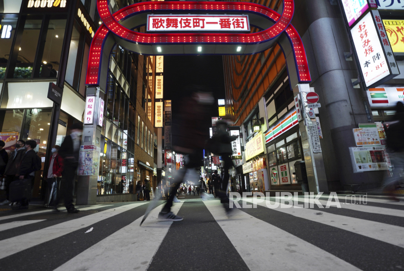  Seorang pria yang mengenakan masker pelindung untuk membantu mengekang penyebaran virus korona berjalan di depan sebuah jalan bar yang populer Rabu, 25 November 2020, di Tokyo. Ibukota Jepang mengonfirmasi lebih dari 400 kasus virus korona baru pada hari Rabu.