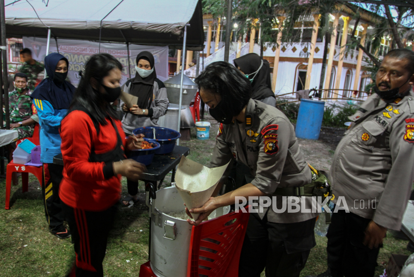 Anggota TNI dari Korem 031/WB dan personel Kepolisian Polda Riau menyiapkan masakan di dapur umum TNI POLRI Peduli Kemanusiaan di Pekanbaru, Riau, Rabu (15/4/2020). Sebanyak 900 nasi kotak dibagikan kepada warga yang terdampak COVID-19 di Pekanbaru sebagai komitmen sinergitas TNI POLRI dalam menangani pandemi COVID-19