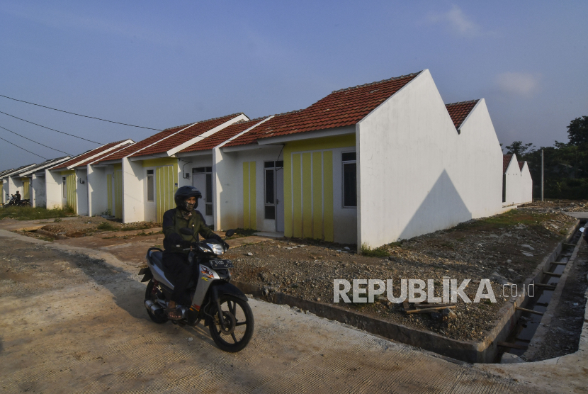 Pengendara motor melintas di samping rumah Kredit Pemilikan Rumah (KPR),Setu, Kabupaten Bekasi, Jawa Barat, Selasa (20/4/2021). Pada tahun 2021 pemerintah melalui Kementerian PUPR menganggarkan dana sebesar Rp16,6 triliun untuk Fasilitas Likuiditas Pembiayaan Perumahan (FLPP) sebanyak 157.500 unit rumah KPR bersubsidi. 