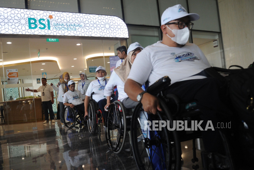 Peserta disabilitas mengunakan kursi roda melintas akan menaiki mobil khusus saat mengikuti BSI Mudik Bareng BUMN di Jakarta, Selasa  (18/4/2023). 