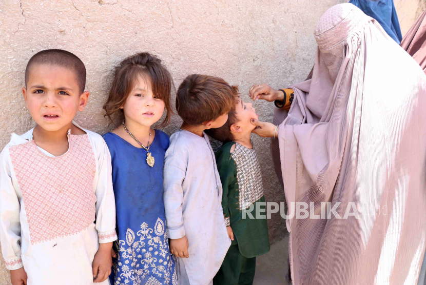  Petugas kesehatan Afghanistan melakukan vaksinasi polio kepada anak-anak di Kandahar, Afghanistan. Taliban sempat melarang vaksinasi polio di wilayah yang menjadi kekuasaannya karena takut ada mata-mata.