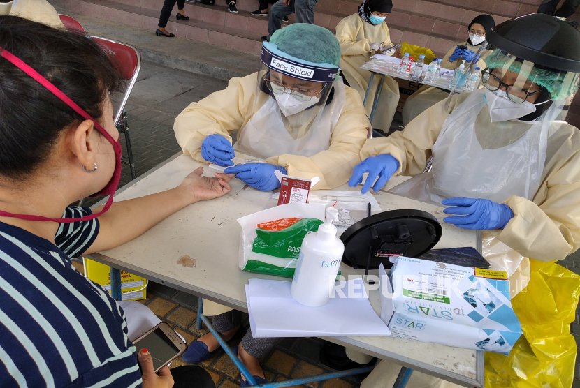 Tenaga medis mengambil sampel darah pedagang saat Rapid Diagnostic Test (RDT) Covid-19 di Pasar Bantul, Yogyakarta, Rabu (24/6). 