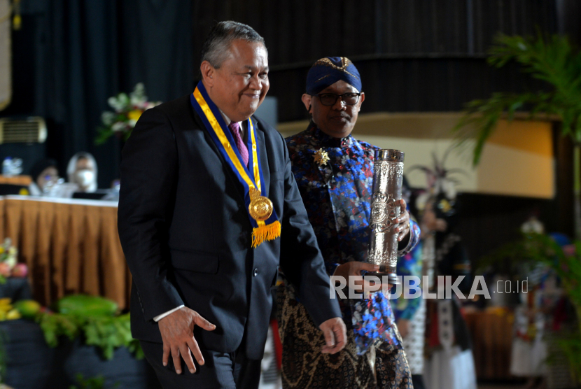 Gubernur Bank Indonesia Perry Warjiyo usai menerima Anugerah Hamengku Buwono IX saat acara Puncak Dies Natalis ke-73 Universitas Gajah Mada (UGM) di Graha Sabha Pramana, Yogyakarta, Senin (19/12/2022). Tema Dies Natalis ke-73 UGM pada tahun ini tentang Pangan Berdaulat, Generasi Sehat, Bangsa Bermartabat . Selain itu, juga diberikan anugerah Hamengku Buwono IX kepada Gubernur BI Perry Warjiyo.