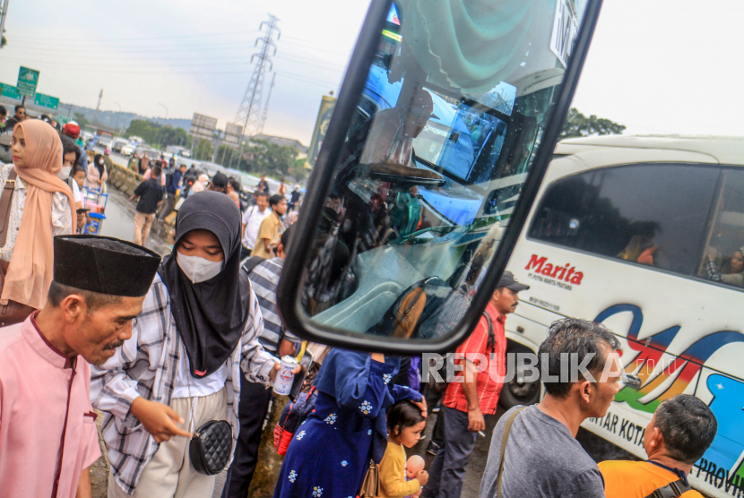 Sejumlah pemudik menunggu bus di terminal bayangan, Simpang Ciawi, Kabupaten Bogor, Jawa Barat, Senin (9/5/2022). Pada arus balik Lebaran H+6 pemudik dari wilayah Sukabumi, Cianjur dan Bogor yang ingin kembali ke Jakarta mulai memadati terminal bayangan di kawasan tersebut. 