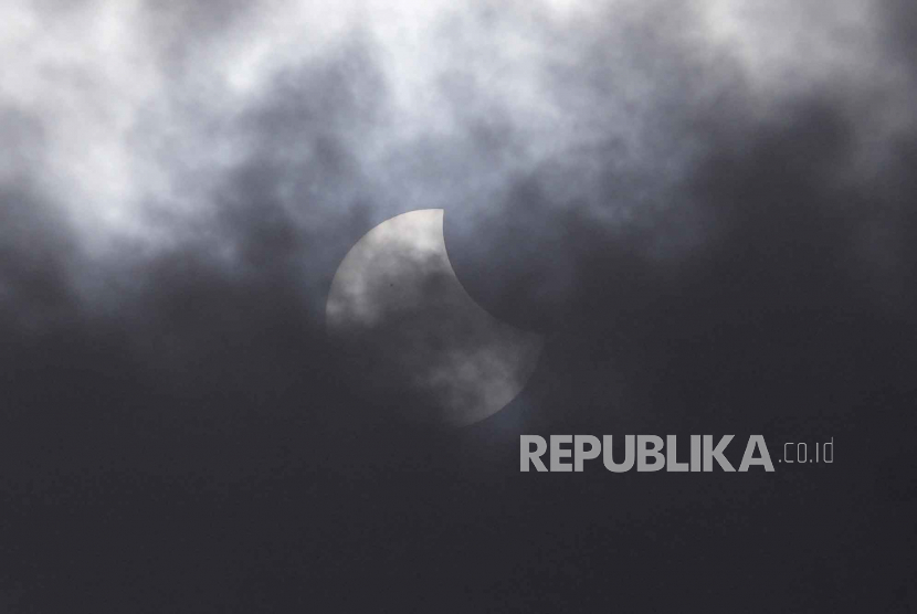 Gerhana matahari sebagian terlihat melalui awan di atas Jakarta, Indonesia, Kamis, (20/4/2023). Gerhana matahari langka akan melintas di pelosok Australia, Indonesia, dan Timor Leste pada Kamis.