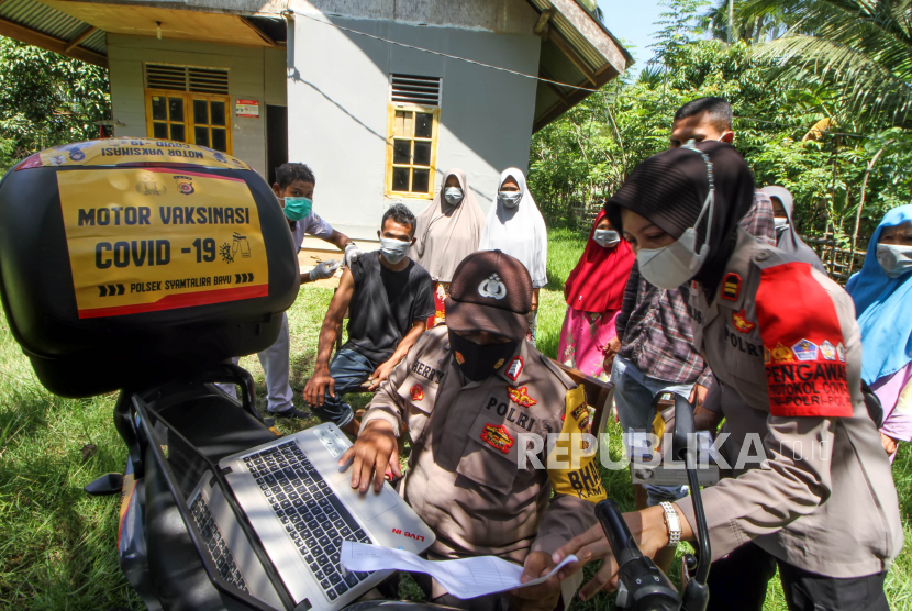 Petugas layanan motor vaksinasi COVID-19 Bhabinkamtibmas Polsek Syamtalira Baru melayani warga yang akan melakukan vaksinasi COVID-19 di Desa Glong, Aceh Utara, Aceh, Senin (13/6/2022). Polsek di jajaran Polres Lhokseumawe meluncurkan layanan jemput bola vaksinasi COVID-19 dengan sepeda motor ke desa-desa pedalaman yang tidak dapat dilalui kendaraan roda empat guna memberikan kemudahan kepada warga yang kesulitan mendatangi lokasi vaksinasi sekaligus untuk mendorong percepatan capaian vaksinasi COVID-19.