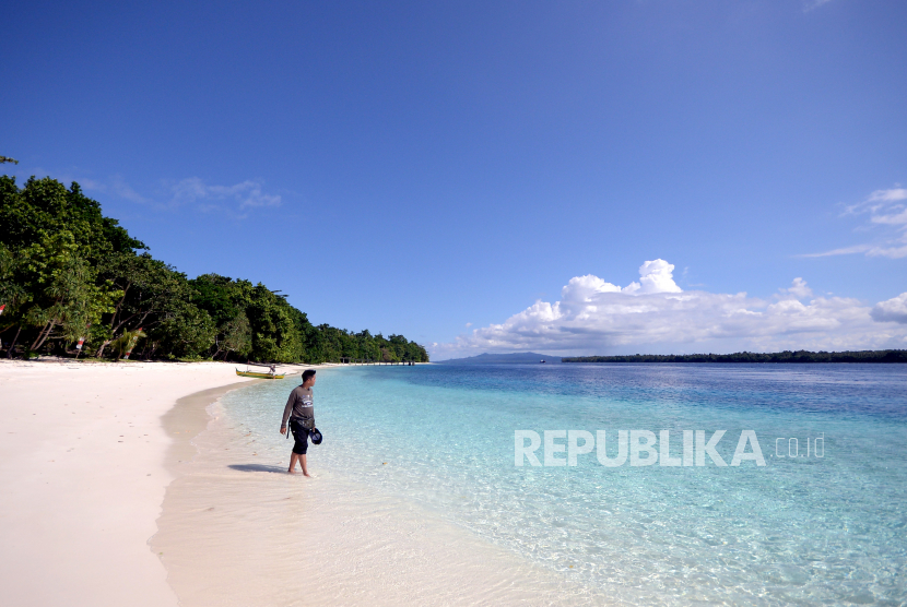 Seorang wisatawan domestik berjalan di pantai pasir putih Pulau Sara, Kabupaten Talaud, Sulawesi Utara, Selasa (26/10/2021). Pulau Sara merupakan objek wisata yang menawarkan panorama alam pantai dan air laut yang jernih, yang dapat ditempuh menggunakan kapal laut dari Manado selama delapan jam. 