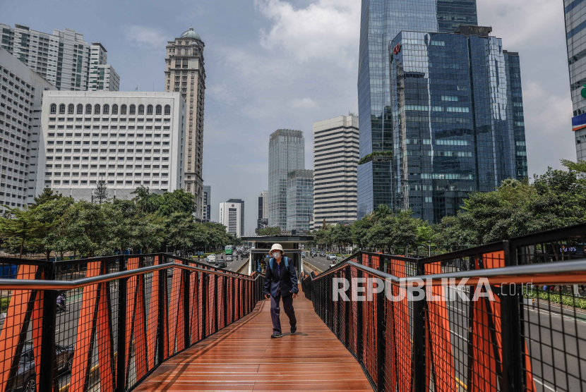 A woman walks on a crossing bridge at a business area in Jakarta, Indonesia, 6 November 2023. (ilustration)