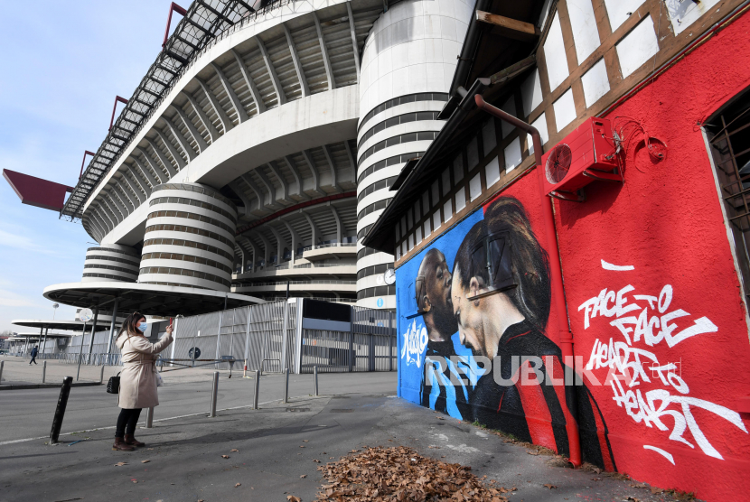 Seorang wanita mengambil foto mural di dekat Stadion Giuseppe Meazza, yang menggambarkan Romelu Lukaku (kiri) dari Inter Milan dan Zlatan Ibrahimovic dari AC Milan bertengkar saat pertandingan Piala Italia, di Milan, Italia, 15 Februari 2021. Inter Milan dan AC Milan akan bermain melawan satu sama lain pada 21 Februari 2021 dalam pertandingan puncak Serie A Italia.
