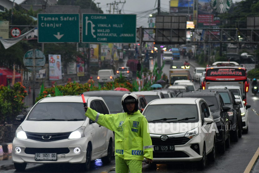 Anggota Satlantas Polres Bogor mengatur arus lalu lintas di Simpang Gadog, Ciawi, Kabupaten Bogor, Jawa Barat, Selasa (26/12/2023). 