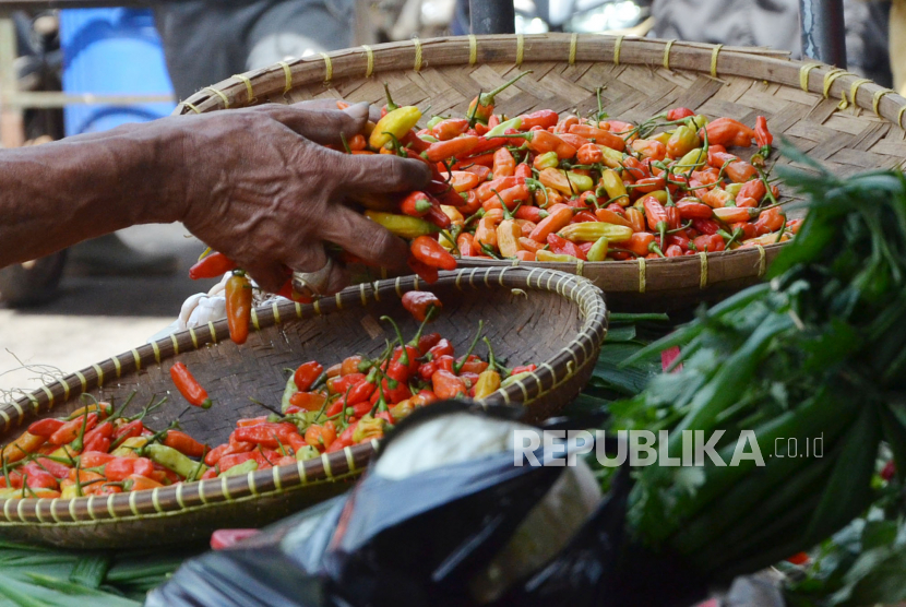 Pedagang sayur memilah cabai rawit di pasar. 