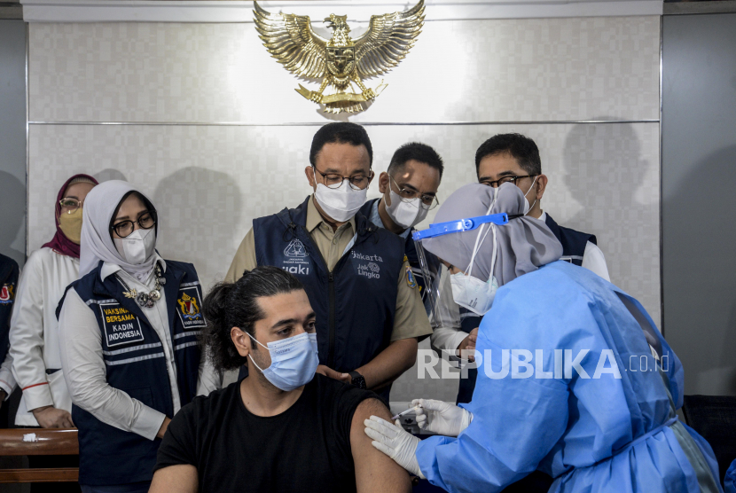 Gubernur DKI Jakarta Anies Baswedan melihat Warga Negara Asing (WNA) saat disuntik vaksin Covid-19 di Balai Kota DKI Jakarta, Selasa (24/8). 