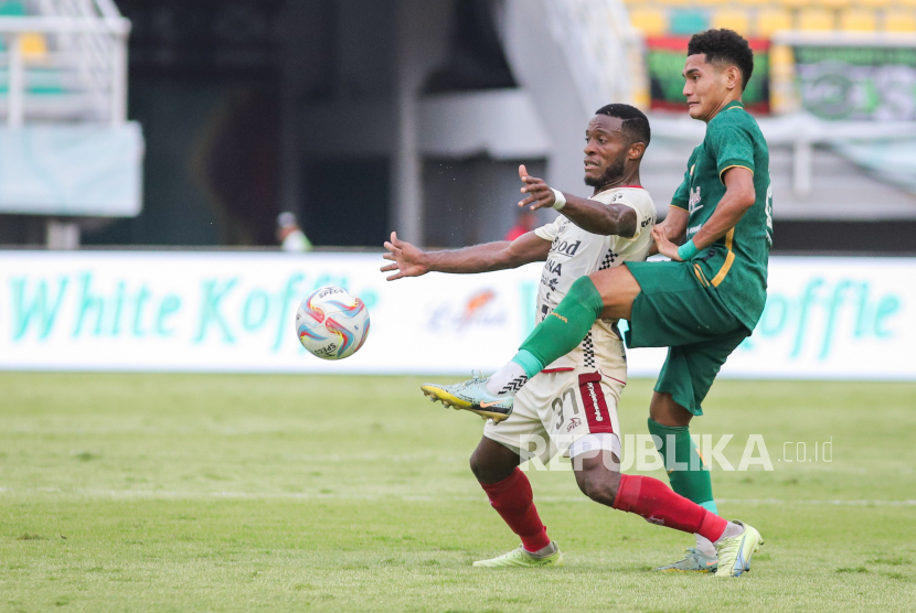 Pesepak bola Persebaya Surabaya Mikael Alfredo Tata (kanan) berebut bola dengan pesepak bola Bali United Privat Mbarga (kiri) pada pertandingan BRI Liga 1 di Stadion Gelora Bung Tomo, Surabaya, Jawa Timur, Rabu (24/4/2024). Bali United menang 2-0 atas Persebaya Surabaya. 
