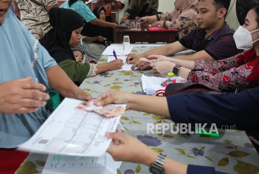 Warga antre untuk menerima Bantuan Langsung Tunai (BLT) peralihan dari bantuan permakanan di Kantor Kecamatan Pabean Cantian, Surabaya, Jawa Timur, Kamis (4/1/2024). 