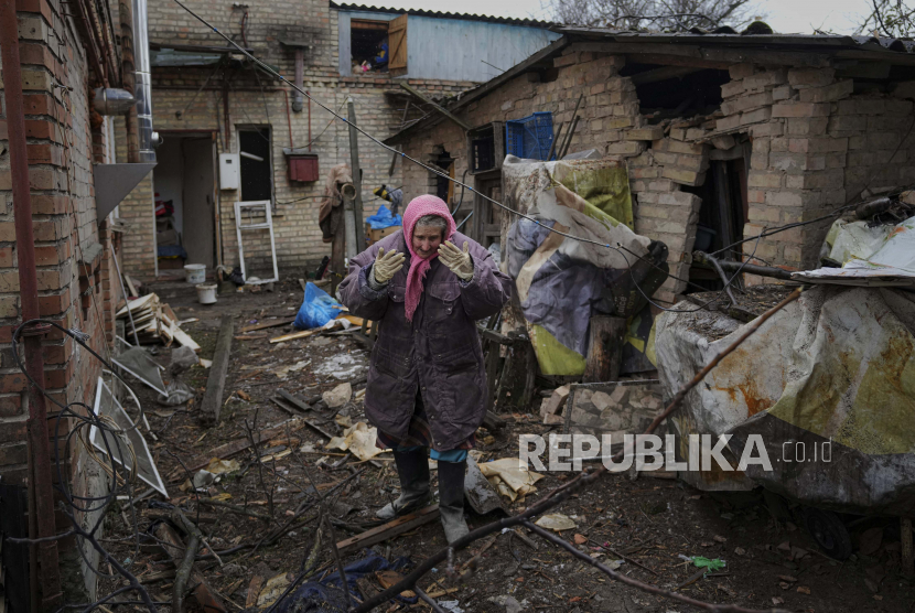 Seorang wanita diliputi oleh emosi di halaman belakang sebuah rumah yang rusak akibat serangan udara Rusia, menurut penduduk setempat, di Gorenka, di luar ibukota Kyiv, Ukraina, Rabu, 2 Maret 2022.
