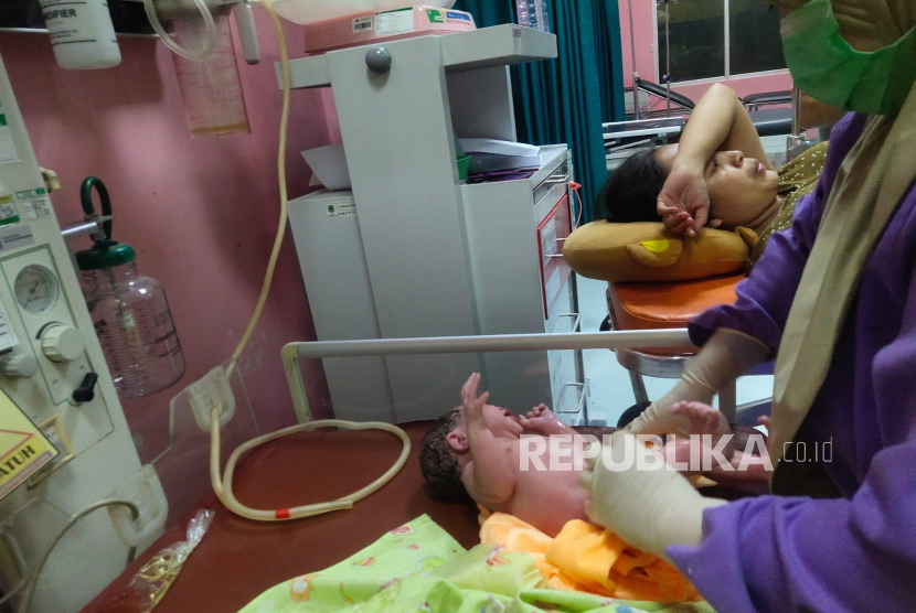 Polisi membantu mengevakuasi pemudik yang hendak melahirkan di rest area KM 166 Tol Cipali, Senin (1/5/2023). Pemudik asal Tegal yang hendka kembali ke Depok itu dikawal menggunakan ambulance menuju ke RSUD Cideres Majalengka.  