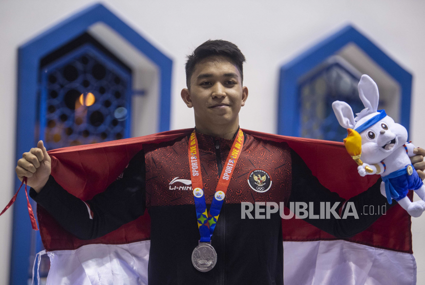 Perenang Indonesia Farrel ArmandioTangkas menunjukan medali perak seusai penyematan medali pada nomor 100m gaya punggung putra saat SEA Games 2023 di Aquatics Center, Morodok Techno National Stadium, Kamboja, Sabtu (6/5/2023). Farrel meraih medali perak usai finis kedua dengan catatan waktu 55,80 detik sementara perenang Singapura Zheng Wen Quah meraih medali emas dengan catatan waktu 55,22 detik dan perenang Filipina Jerard Dominic Jacinto meraih medali perunggu dengan catatan waktu 55,99. 