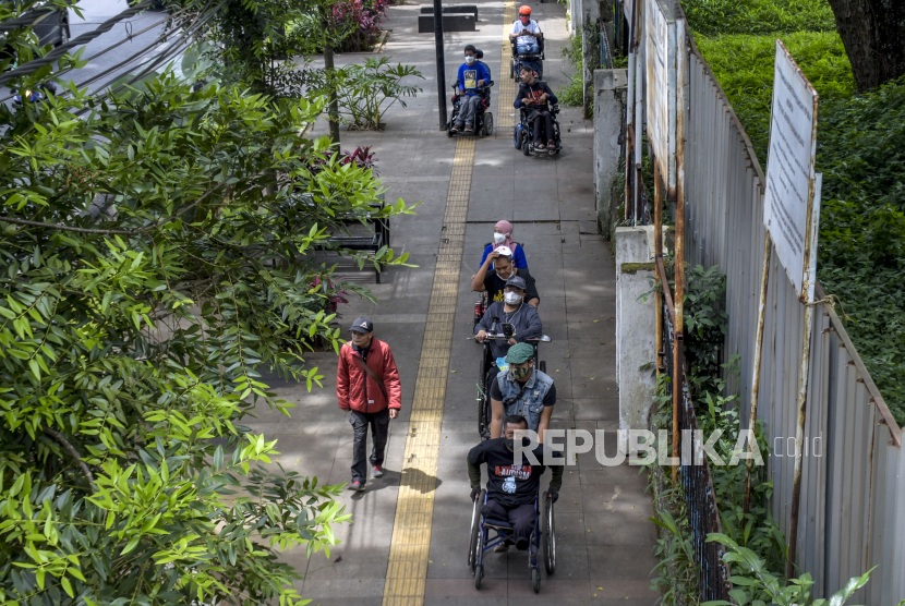 Warga difabel menggunakan kursi roda melintasi trotoar di ruas Jalan Ir H Djuanda saat peringatan Hari Kursi Roda Internasional, Selasa (1/3/202