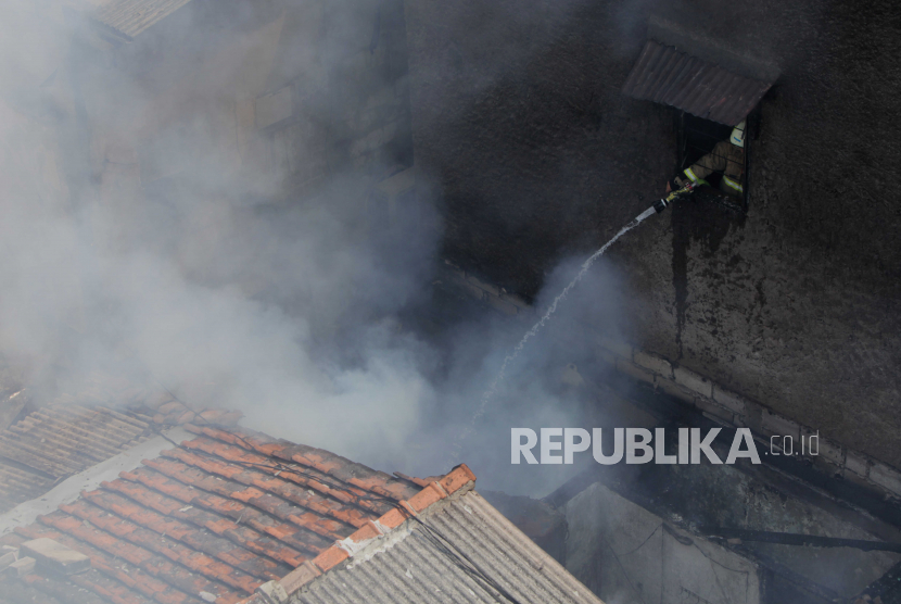 Petugas damkar memadamkan api saat terjadi kebakaran di Gang Anggrek 2, Karet Kuningan, Setiabudi, Jakarta Selatan, Jumat (21/7/2023). Kebakaran permukiman penduduk yang diduga akibat korsleting listrik tersebut membuat belasan rumah  habis terbakar dan sekitar 200 jiwa dari 40 KK terpaksa harus mengungsi.