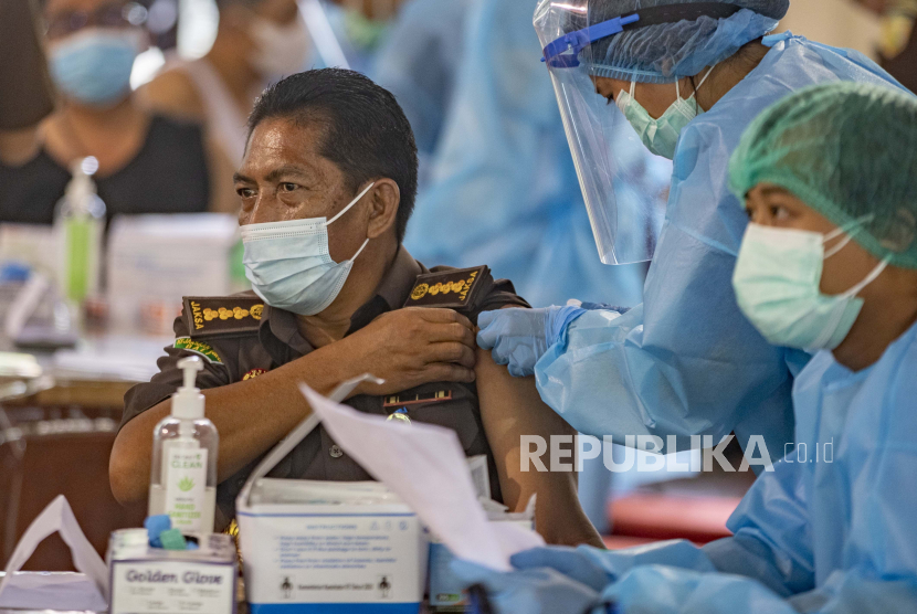  Seorang pria menerima suntikan vaksin COVID-19 saat melakukan vaksinasi di Denpasar, Bali, Indonesia, 09 Maret 2021. Badan Pengawas Obat dan Makanan (BPOM) Indonesia telah menyetujui vaksin AstraZeneca COVID-19 untuk penggunaan darurat pada 09 Maret 2021.