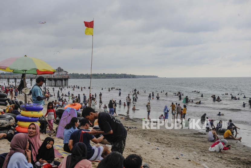 Wisatawan menikmati suasana Pantai Anyer di Kabupaten Serang, Banten, Senin (1/1/2024). Dinas Kepemudaan Pariwisata dan Olahraga (Disporapar) Kabupaten Serang mencatat jumlah kunjungan wisatawan ke kawasan Pantai Anyer pada libur Natal dan tahun baru 2024 mencapai 267.042 orang.