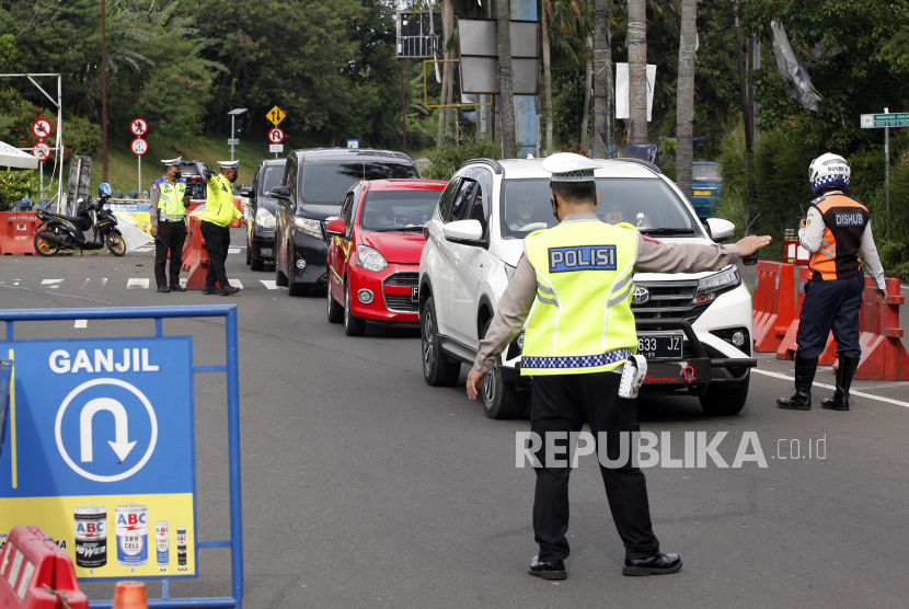 Petugas Sat Lantas Polres Bogor dan petugas Dishub Kabupaten Bogor mengarahkan kendaraan wisatawan saat pemberlakuan satu jalur ke Puncak. (Ilustrasi)