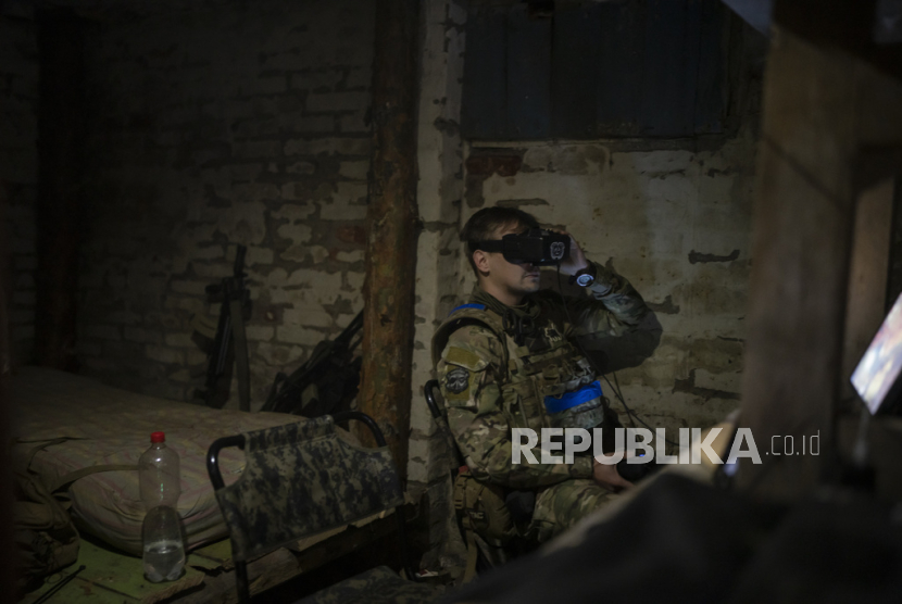 Seorang tentara Ukraina yang dijuluki Bakeneko mengenakan layar yang dipasang di kepala saat mengoperasikan drone dari ruang bawah tanah di pinggiran Kremmina, Ukraina,  beberapa waktulalu.