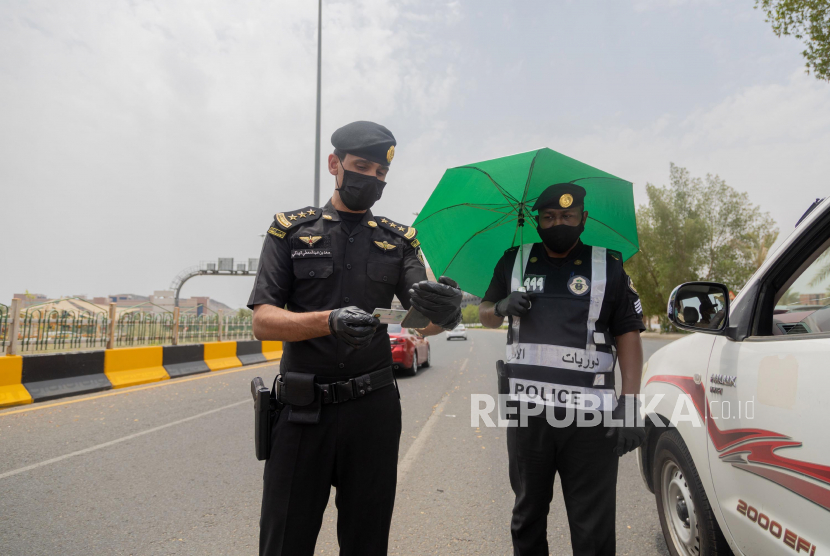 Sebuah foto selebaran yang disediakan oleh Kementerian Media Saudi pada tanggal 27 Juli 2020 menunjukkan bahwa polisi berjaga di pos pemeriksaan di Makkah, Arab Saudi, 26 Juli 2020. Arab Saudi Wajibkan Penumpang Memakai Sabuk Pengaman