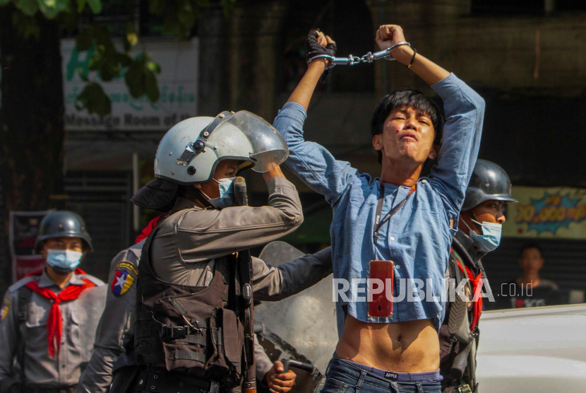 Seorang pengunjuk rasa pro-demokrasi ditahan oleh petugas polisi anti huru hara selama unjuk rasa menentang kudeta militer di Yangon, Myanmar, 27 Februari 2021. 