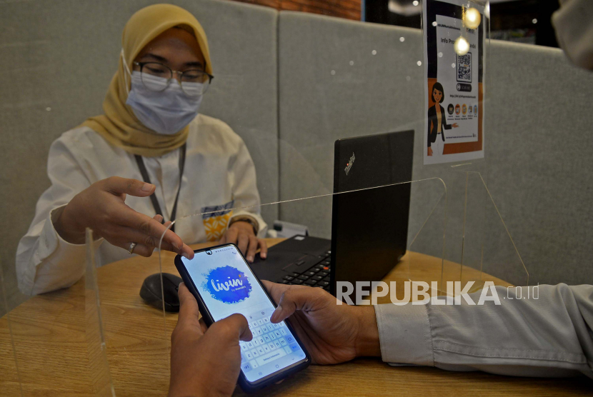 Customer service membantu nasabah melakukan aktivasi aplikasi mobile banking Livin Bank Mandiri di Kantor Cabang Mal Senayan City, Jakarta, Selasa (7/9). Pola transaksi nasabah selama masa pandemi secara tidak langsung mulai bergeser dari transaksi tunai ke digital. Tercatat hingga Juni 2021 jumlah pengguna Livin by Mandiri yang terdaftar telah mencapai 7,8 juta user dengan nilai transaksi mencapai Rp 728,9 triliun atau tumbuh 59% secara year on year (YoY).Prayogi/Republika.