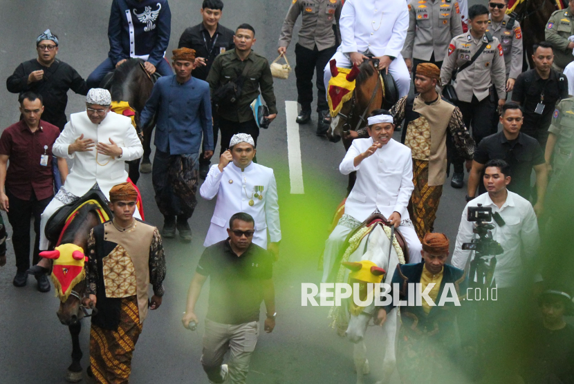 Gubernur Jawa Barat (Jabar) Dedi Mulyadi bersama Wakilnya Erwan Setiawan menunggang kuda menyapa warga saat kirab budaya atau karnaval Jabar Hudang dalam rangka perayaan HUT Provinsi Jawa Barat (Jabar) ke-80, di Kota Bandung, Selasa (19/8). Karnaval yang diikuti seluruh kota dan kabupaten di Jabar ini mengangkat spirit kebangkitan hasil pertanian, industri dan UMKM lokal.