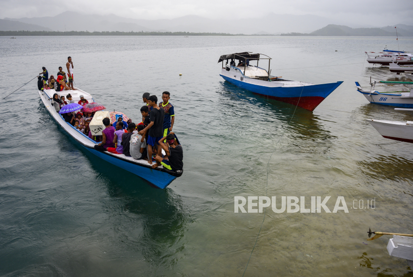 Sejumlah warga menaiki perahu yang akan mengangkut mereka ke pulau lainnya di Pulau Lutungan, Kabupaten Tolitoli, Sulawesi Tengah, Minggu (6/9/2020).  Mobilitas orang dan barang di wilayah pulau-pulau itu hanya mengandalkan perahu sebagai sarana transportasi. 