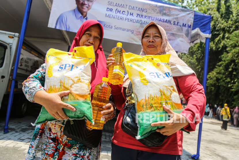 Warga membawa beras dan minyak goreng bantuan sosial pada program gerakan pasar pangan murah  (ilustrasi). 
