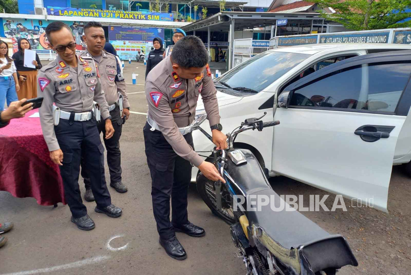 Kasatlantas Polrestabes Bandung Kompol Eko Iskandar melihat mobil Sigra yang menabrak dua sepeda motor dan menyeret salah satu motor di Jalan Pasteur, Kota Bandung, Rabu (18/10/2023).