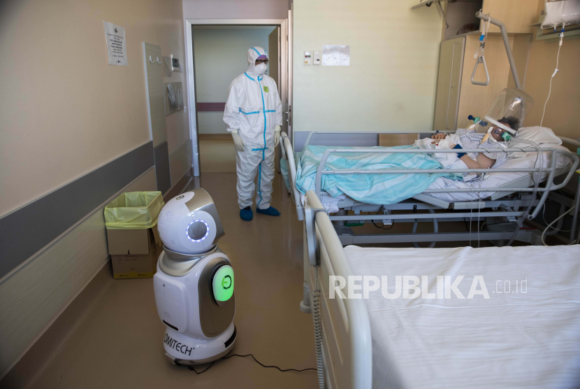 Petugas kesehatan menyiapkan robot di rumah sakit Circolo di Varese, Italia, Rabu (8/4). Enam robot membantu petugas kesehatan dalam membantu pasien Covid-19. Jumlah kematian yang terkait dengan virus corona mencapai 100 ribu orang.