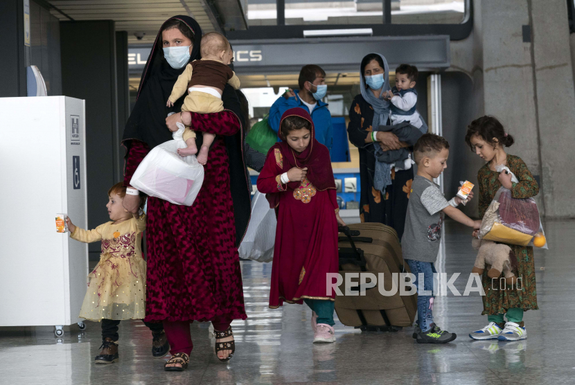 Keluarga yang dievakuasi dari Kabul, Afghanistan, berjalan melewati terminal sebelum naik bus setelah mereka tiba di Bandara Internasional Washington Dulles, di Chantilly, Va, pada Minggu, 29 Agustus 2021.