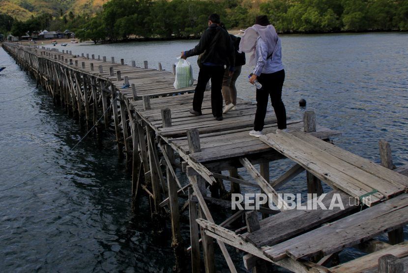 Pengunjung berjalan di atas jembatan titian yang sudah mulai rapuh di Desa Soknar, Kecamatan Komodo, Manggarai Barat, NTT. Bupati Manggarai Heribertus Nabit sebut desa berstatus tertinggal terus berkurang.