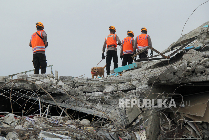 Anggota polisi dengan bantuan Unit Satwa K9 Mades Polri  di Rumah Sakit Mitra Manakarra yang runtuh akibat gempa bumi di Mamuju, Sulawesi Barat, Minggu (17/1/2021). Memasuki hari ke tiga pasca gempa bumi tim SAR, TNI dan Polri masih melakukan pencarian korban di beberapa lokasi. 