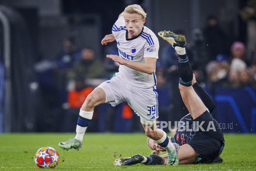 Oscar Hoejlund dari FCK dan Erling Haaland dari Manchester City beraksi selama pertandingan sepak bola leg pertama babak 16 besar Liga Champions UEFA antara FC Copenhagen dan Manchester City, di Kopenhagen, Denmark, Kamis (14/2/2024) dini hari WIB