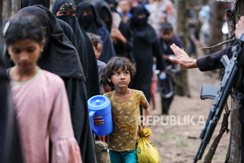 Sejumlah imigran etnis Rohingya berjalan usai terdampar di pantai di kawasan Gampong Baro, Kecamatan Baitussalam, Kabupaten Aceh Besar, Aceh.