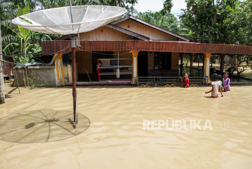 Sejumlah anak menerobos genangan banjir untuk masuk ke rumah mereka yang terendam banjir di Desa Hagu, Batu 5, Kecamatan Lhoksukon, Aceh Utara, Aceh, Juni lalu.