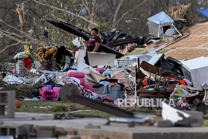 Warga memeriksa rumah yang hancur sehari setelah tornado di Amory, Mississippi, AS, 25 Maret 2023. Sedikitnya 25 orang tewas setelah tornado semalam dan wabah cuaca buruk melanda negara bagian Mississippi, AS.