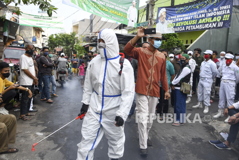 Anggota kepolisian dengan mengenakan hazmat menyemprotkan cairan disinfektan di kawasan Petamburan III, Jakarta Pusat, Minggu (22/11/2020). Penyemprotan tersebut dilakukan menyusul adanya temuan kasus terkonfirmasi positif COVID-19 di kawasan Petamburan. 