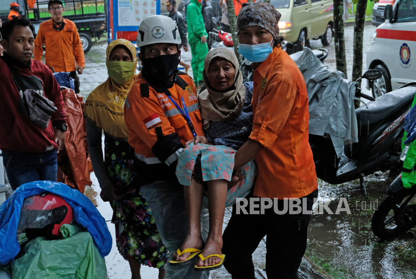 Relawan menggendong pengungsi lansia saat tiba di tempat pengungsian gunung Merapi Desa Banyurojo, Kabupaten Magelang, Jawa Tengah, Selasa (5/1/2021). 