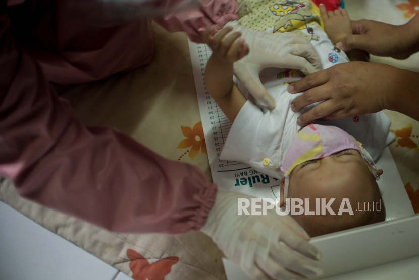 Petugas kesehatan memeriksa seorang balita (ilustrasi). Puluhan balita di Kota Depok, Jawa Barat, terinfeksi Covid-19.