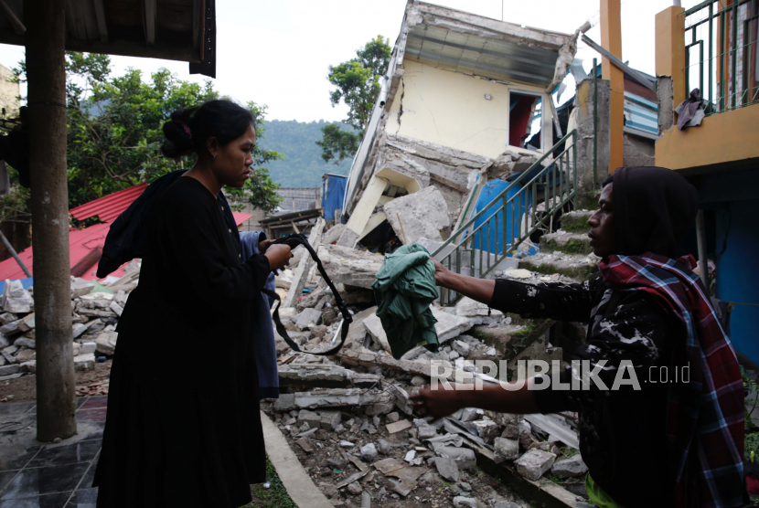 Warga menyelamatkan barang-barang dari rumah mereka yang rusak setelah gempa berkekuatan 5,6 SR, di Cianjur, Indonesia, 22 November 2022. Gempa melanda barat daya Kabupaten Cianjur di Provinsi Jawa Barat, menewaskan 62 orang, menurut Badan Nasional Penanggulangan Bencana (BNPB) Indonesia .