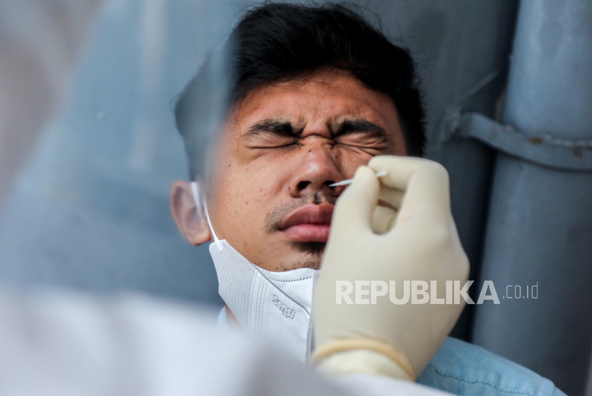 Seorang pria bereaksi saat tes usap COVID-19 di Medan, Sumatera Utara, Indonesia, 23 Februari 2021.