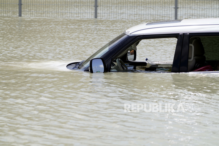 Kendaraan SUV yang ditinggalkan di tengah banjir di Dubai, Uni Emirat Arab. Sebagian orang meyakini bahwa hujan lebat yang memecahkan rekor ini terjadi karena pengaruh aktivitas penyemaian awan.